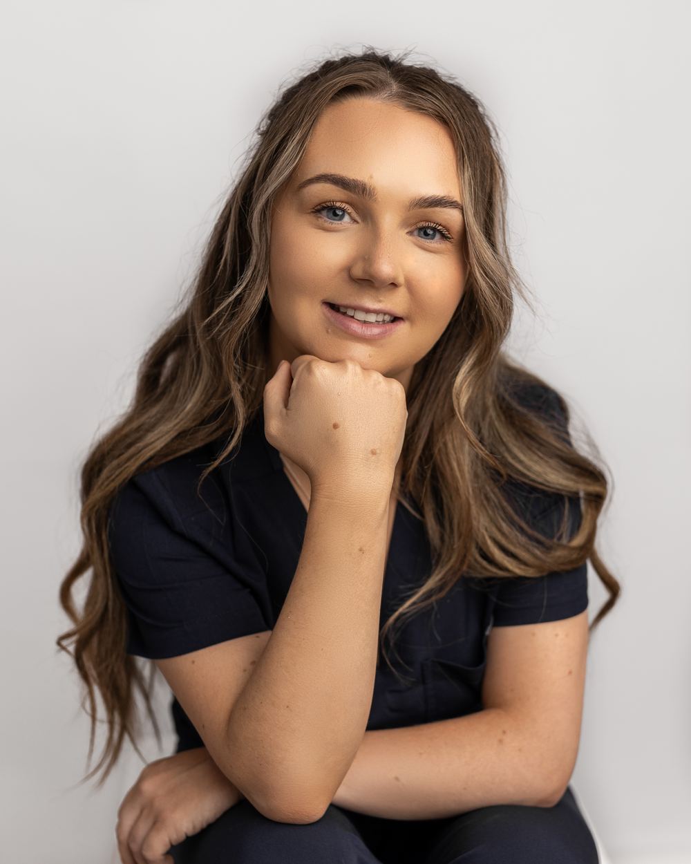 Georgina White, registered nurse, seated with her chin resting on her hand